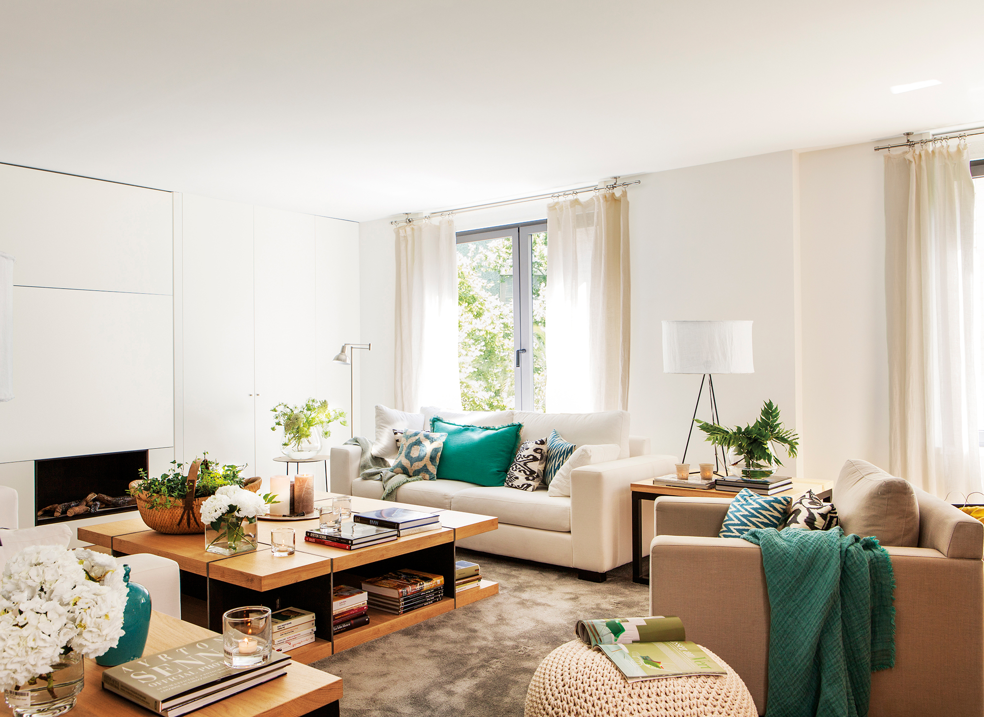 Salón moderno con mesa de centro de diseño de madera, sofá blanco y chimenea.