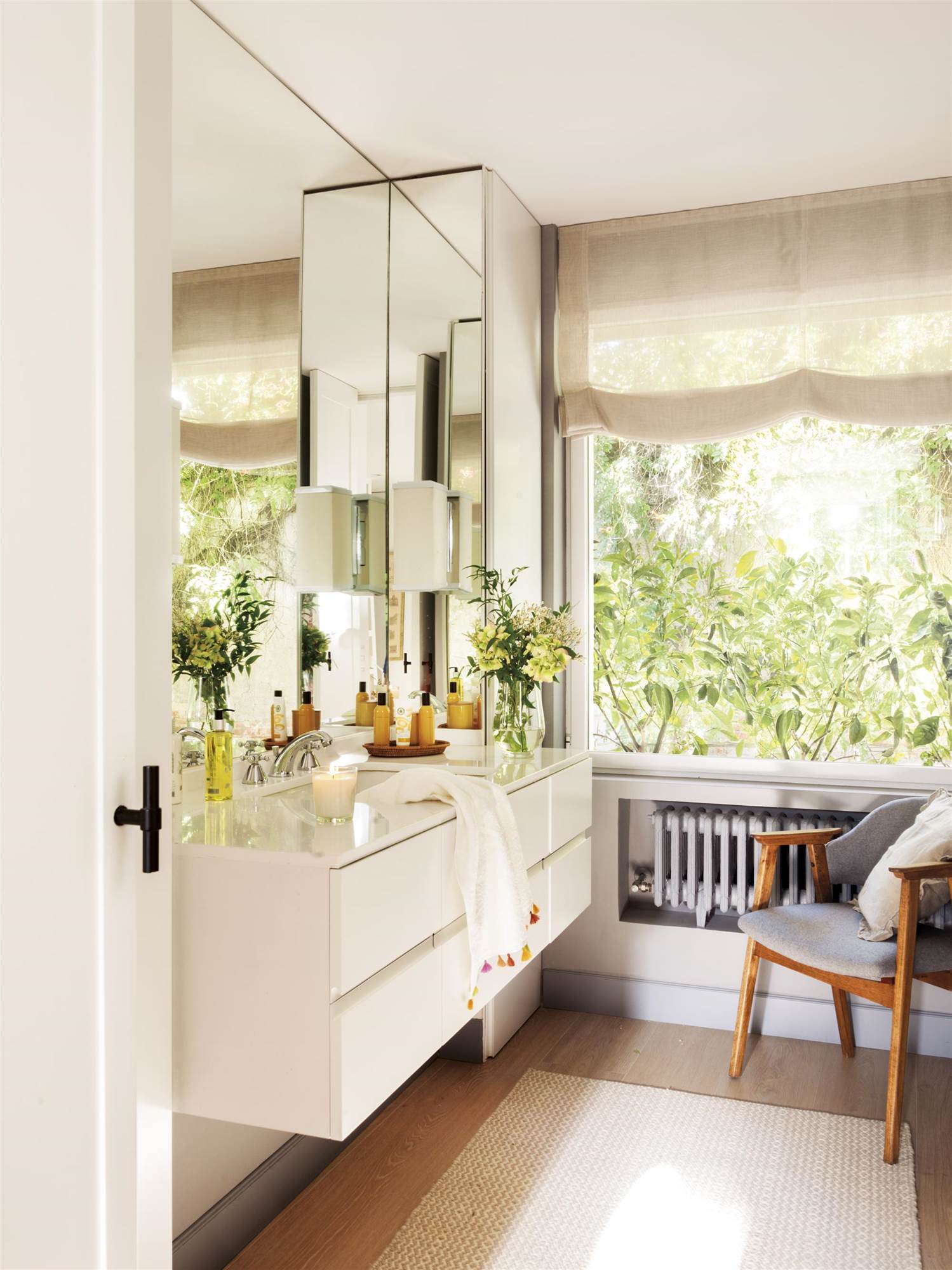 Baño moderno con mueble blanco suspendido y ventana con estor. 