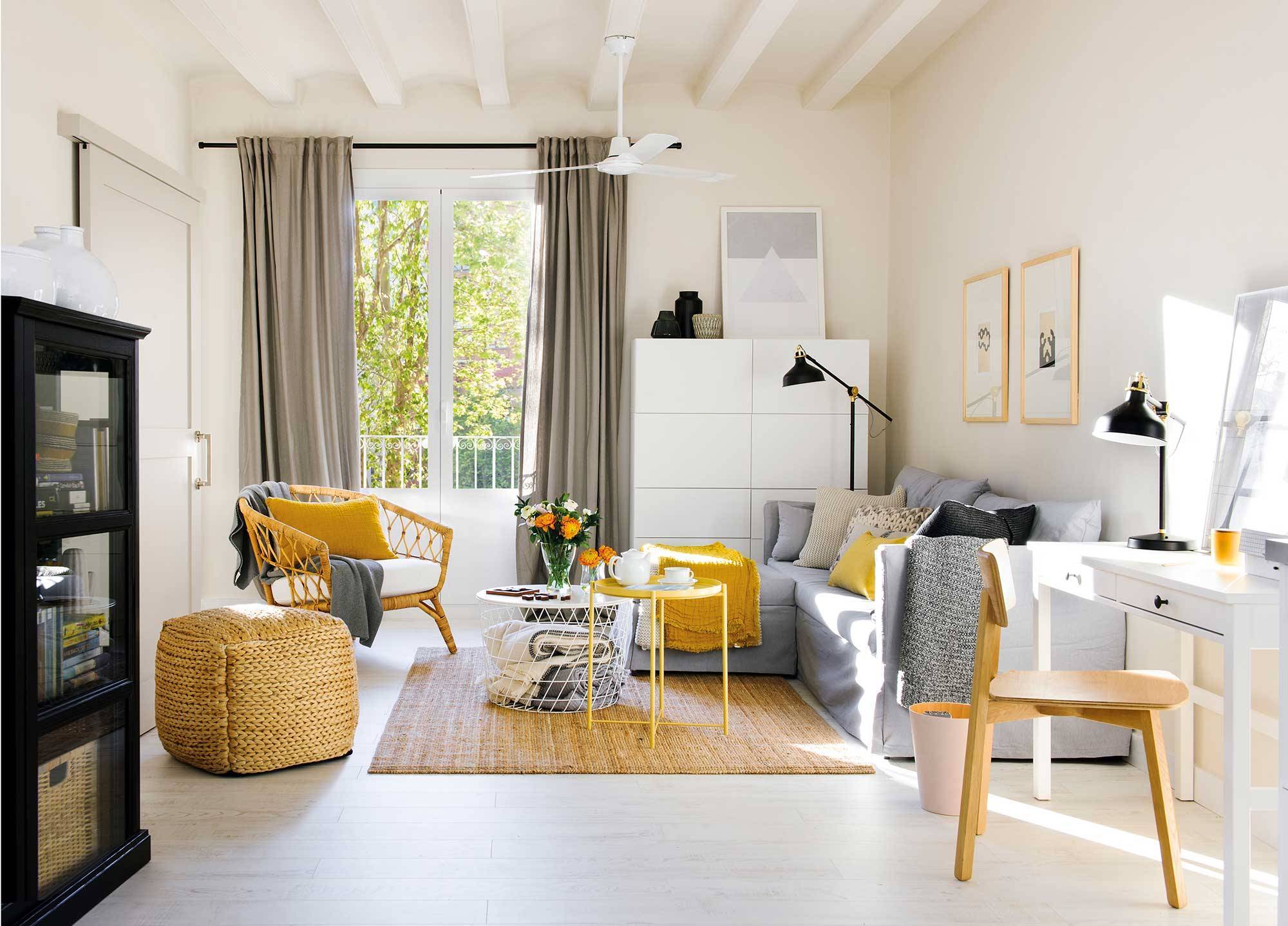 Salón pequeño con sofá gris, butaca de fibras y aparador blanco. 