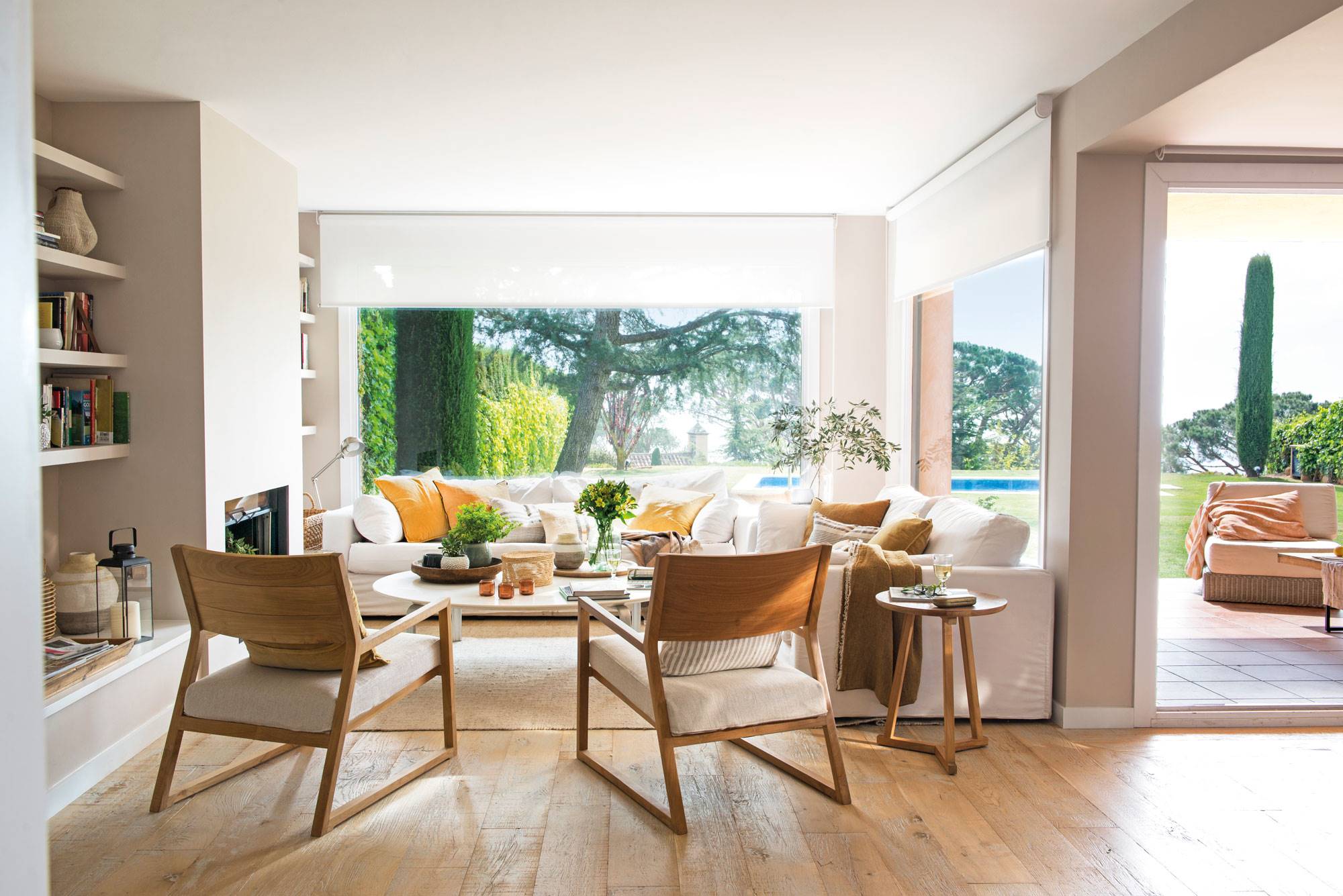 Salón moderno con grandes ventanales al jardín. 