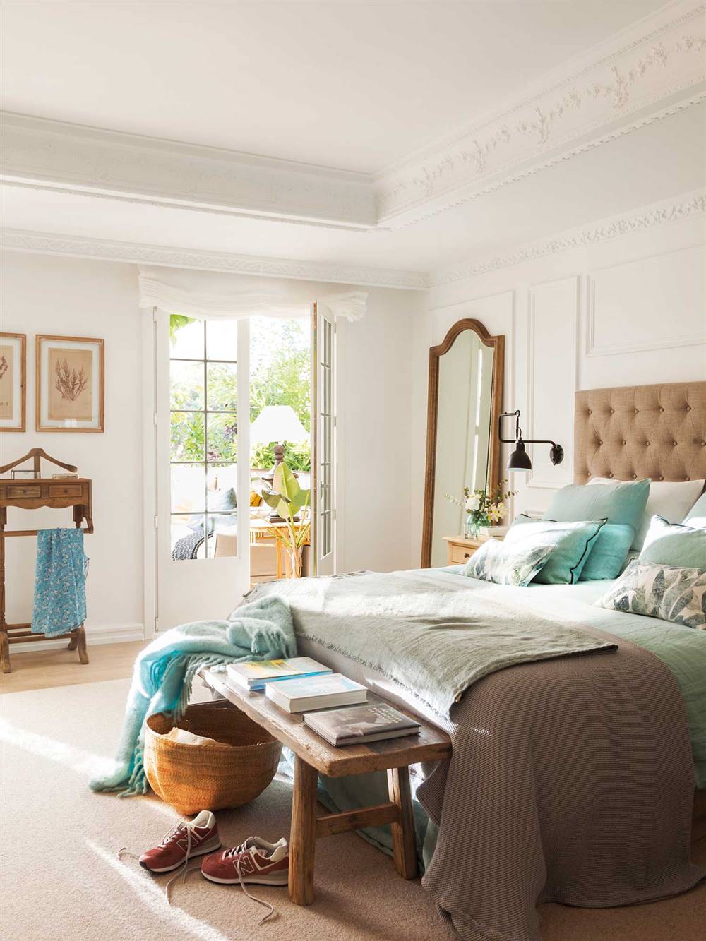 Dormitorio blanco con cabecero en capitoné y muebles de madera