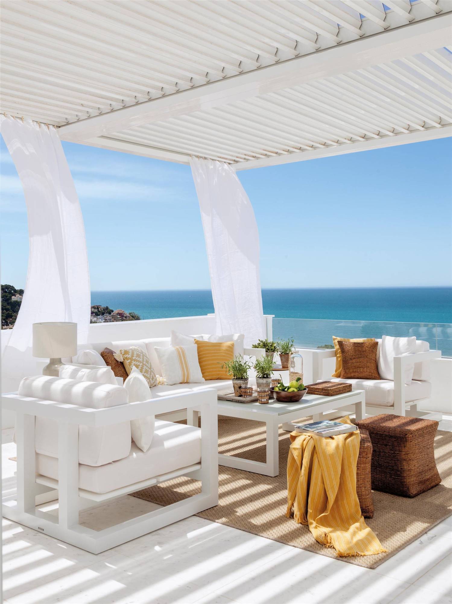 Terraza con pérgola y muebles blancos. 