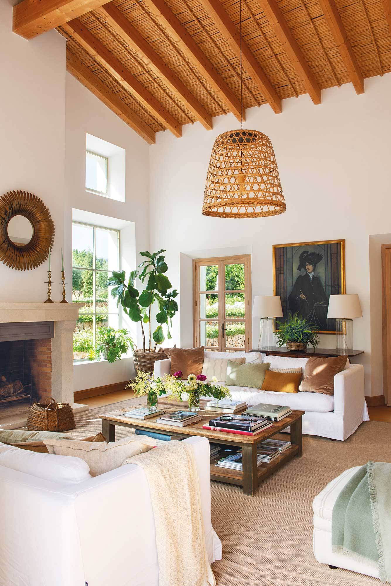 Salón de techos altos de casa de campo con paredes en blanco y vigas. 