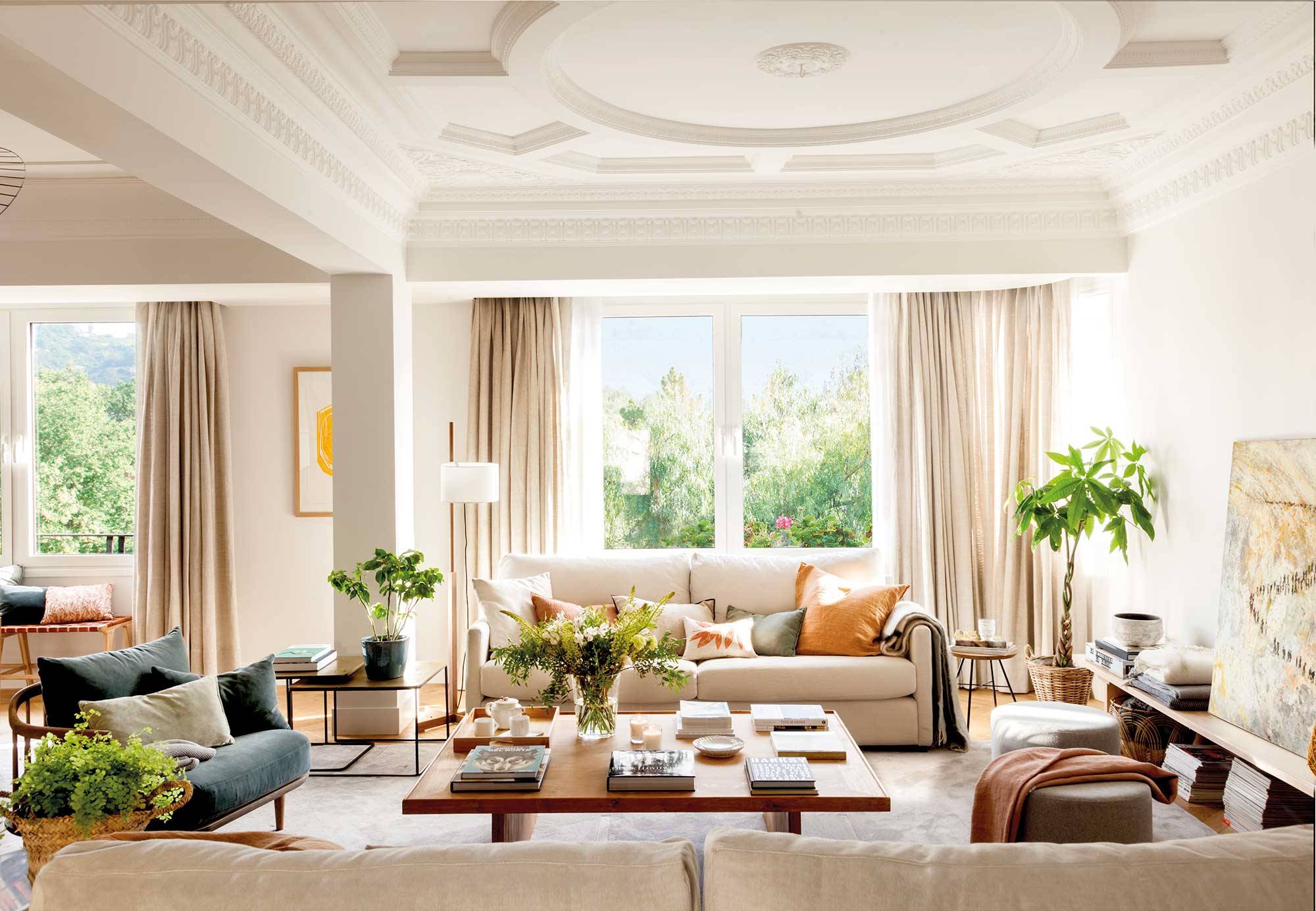 Salón señorial con grandes ventanales y decoración moderna. 