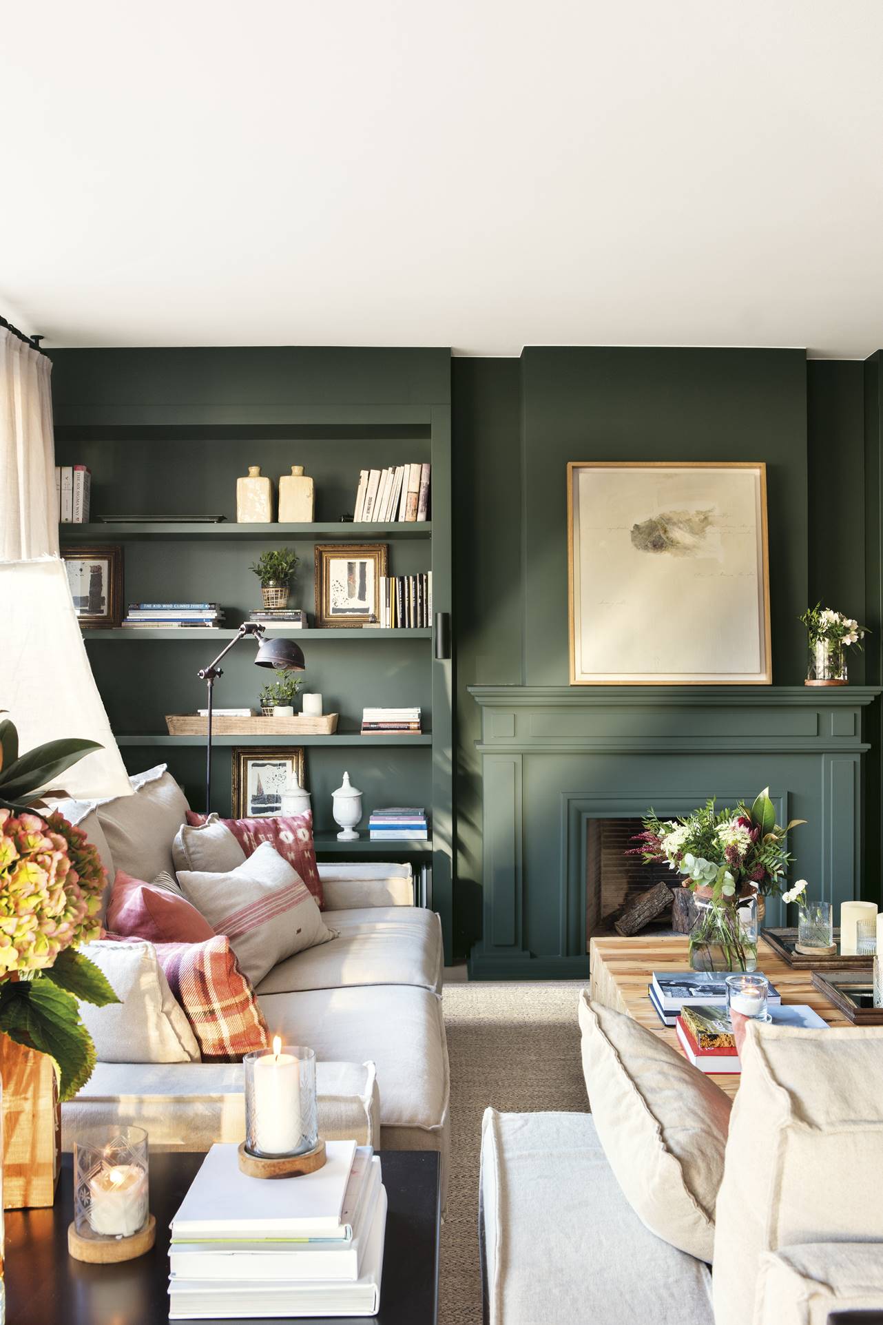 Un salón con la pared de la chimenea en verde oscuro.