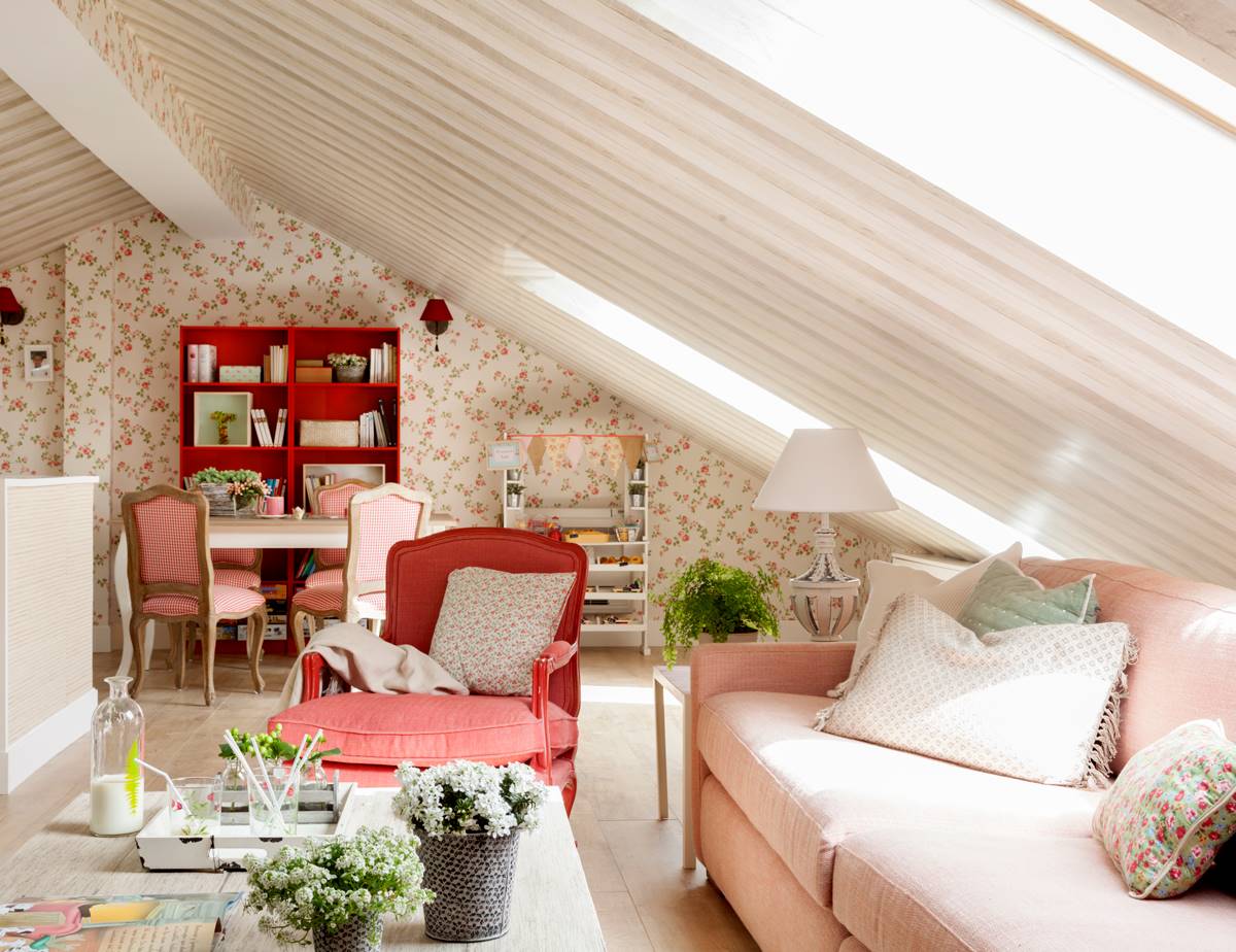 Salón pequeño con techo abuhardillado y sofá rosa. 