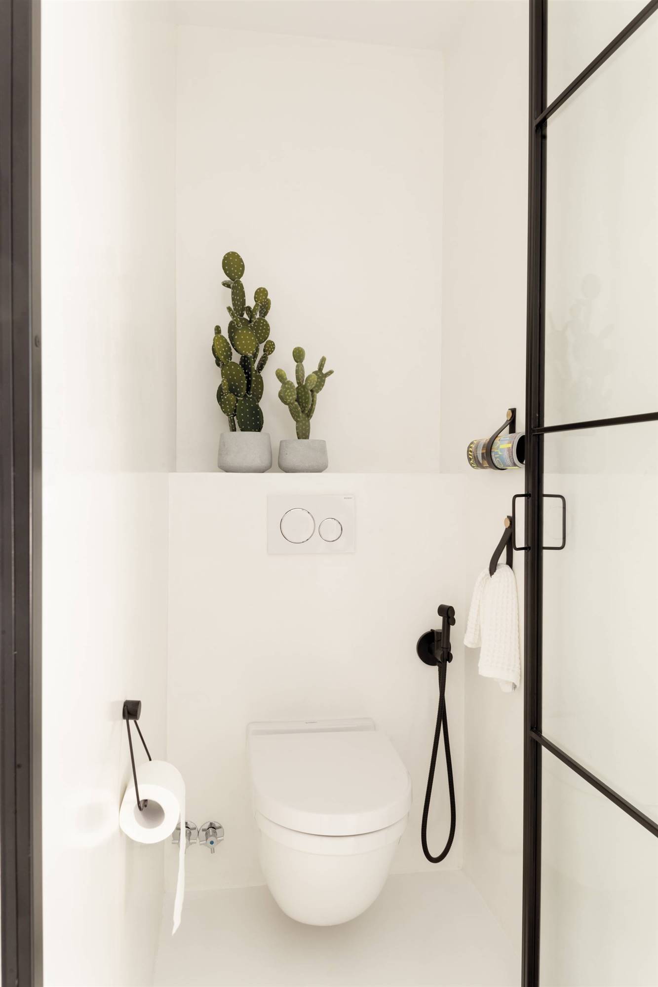 Baño con la zona del sanitario cerrada con una puerta. 