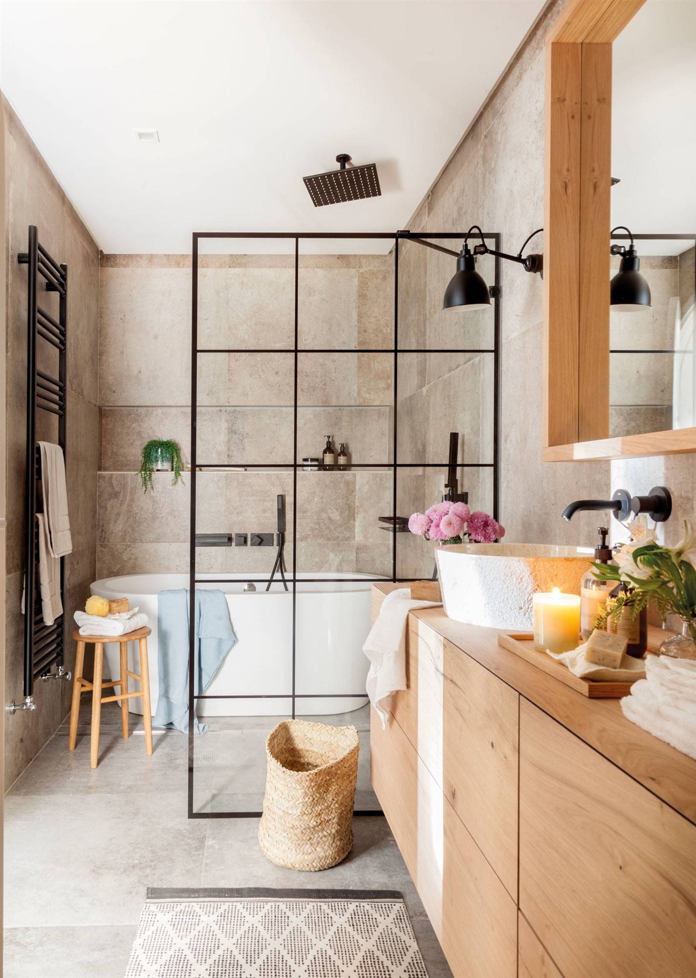 Baño con ducha y bañera detrás de la mampara y mueble de baño de madera. 