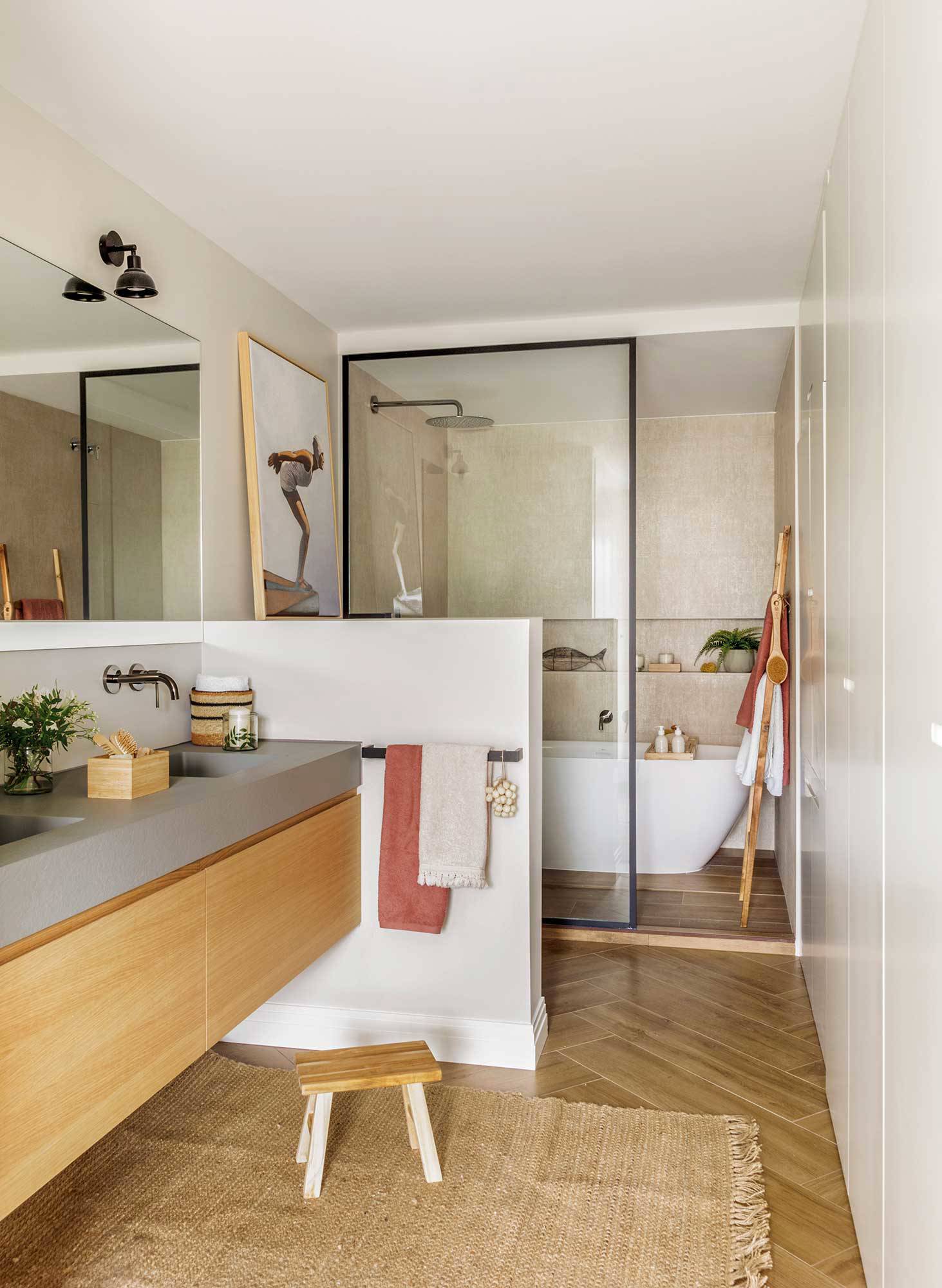 Ban~o moderno con gran mueble volado y murete que separa del inodor y gran ducha.