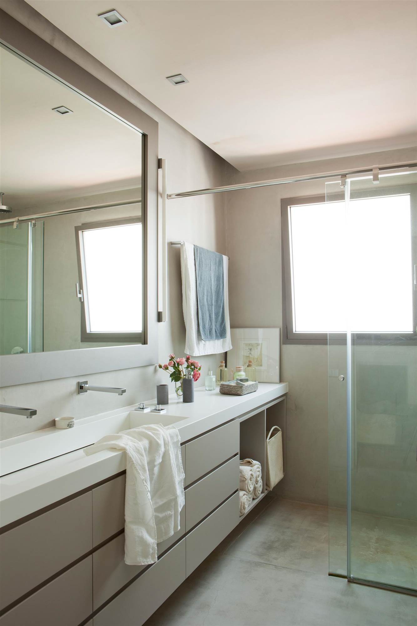 Baño moderno con mueble gris con encimera blanca. 