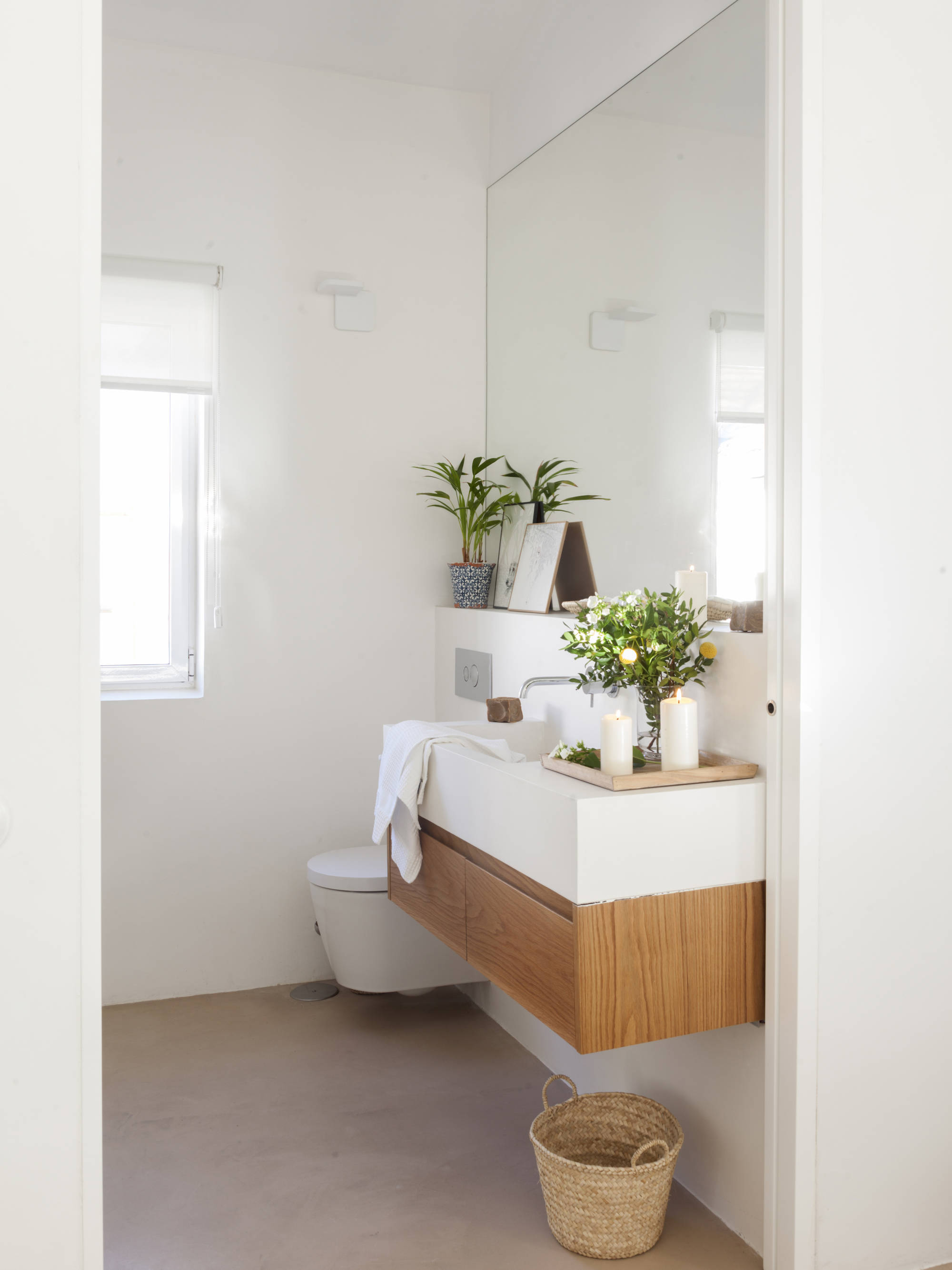 Baño con mueble e inodoro volado, y repisa bajo el espejo.