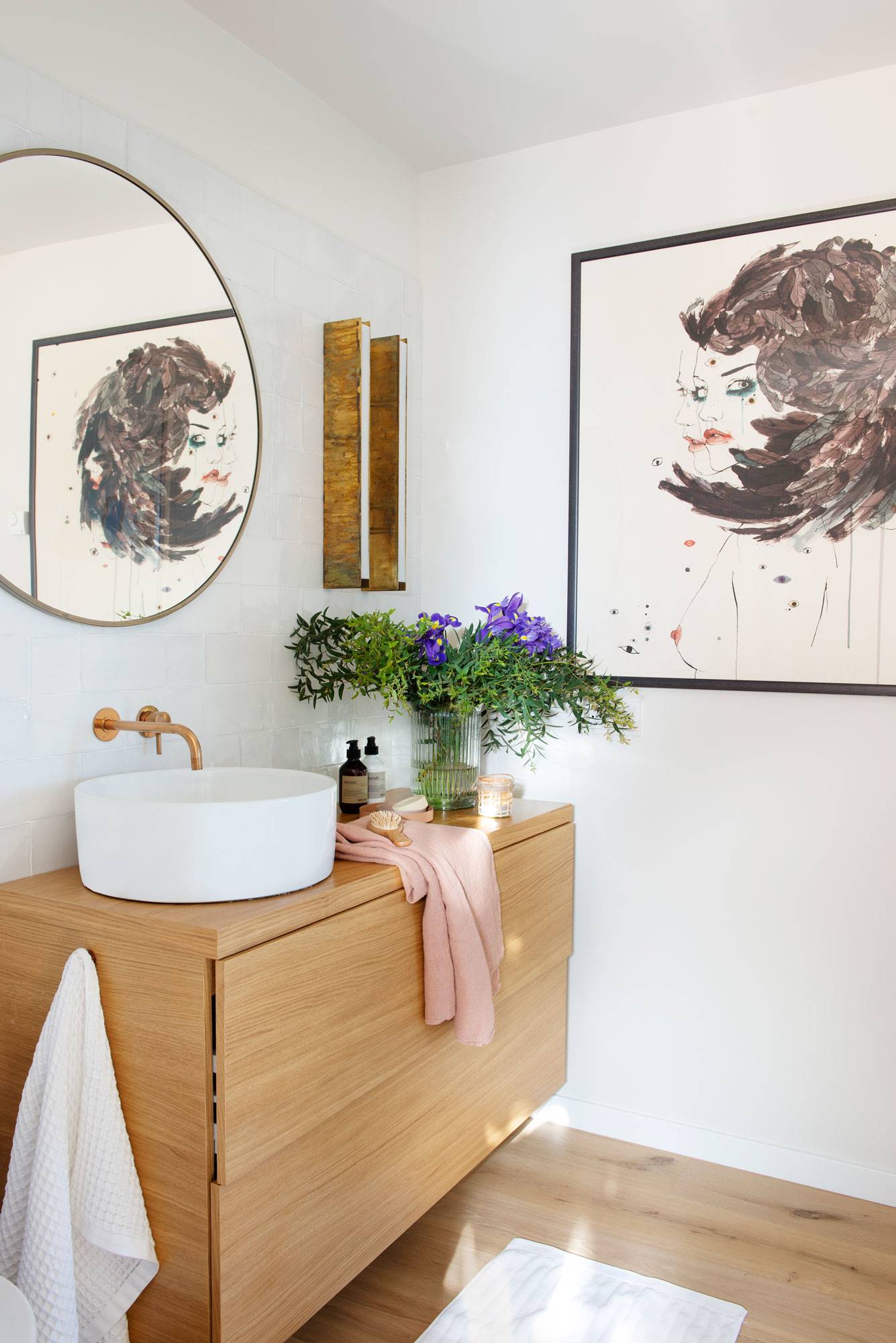 Baño con mueble en madera y espejo redondo. 