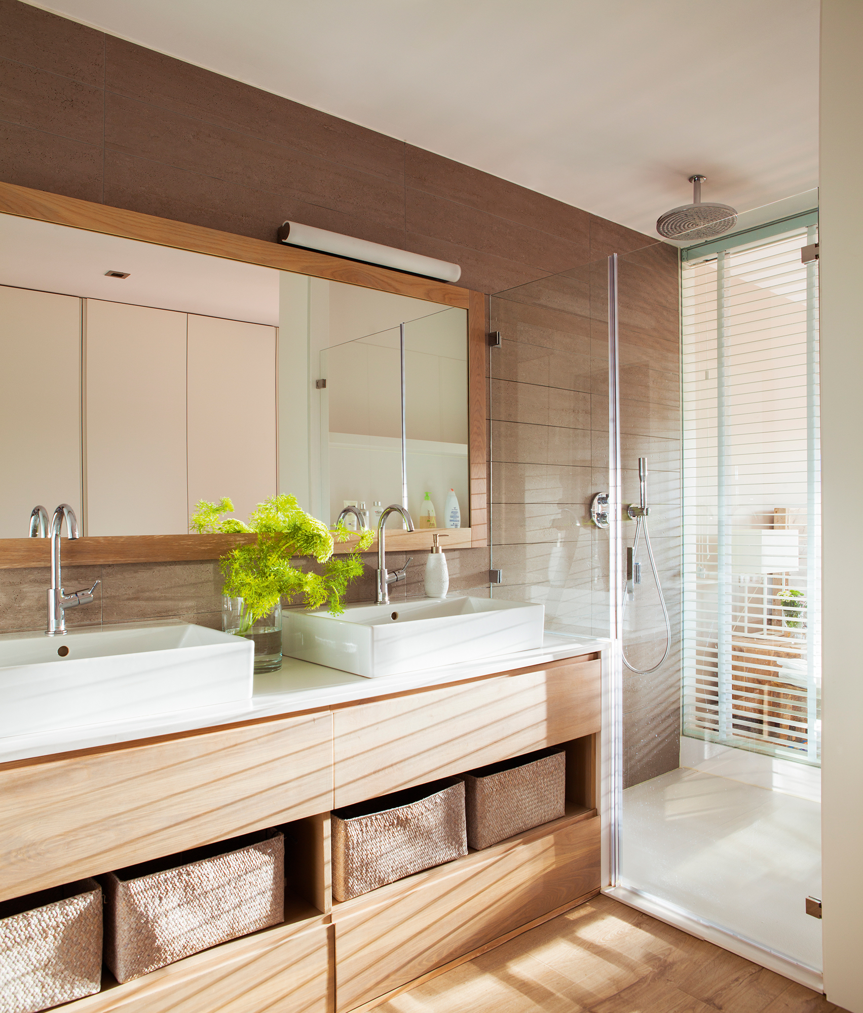 Baño moderno con mueble en madera y mampara de cristal sin perfiles. 
