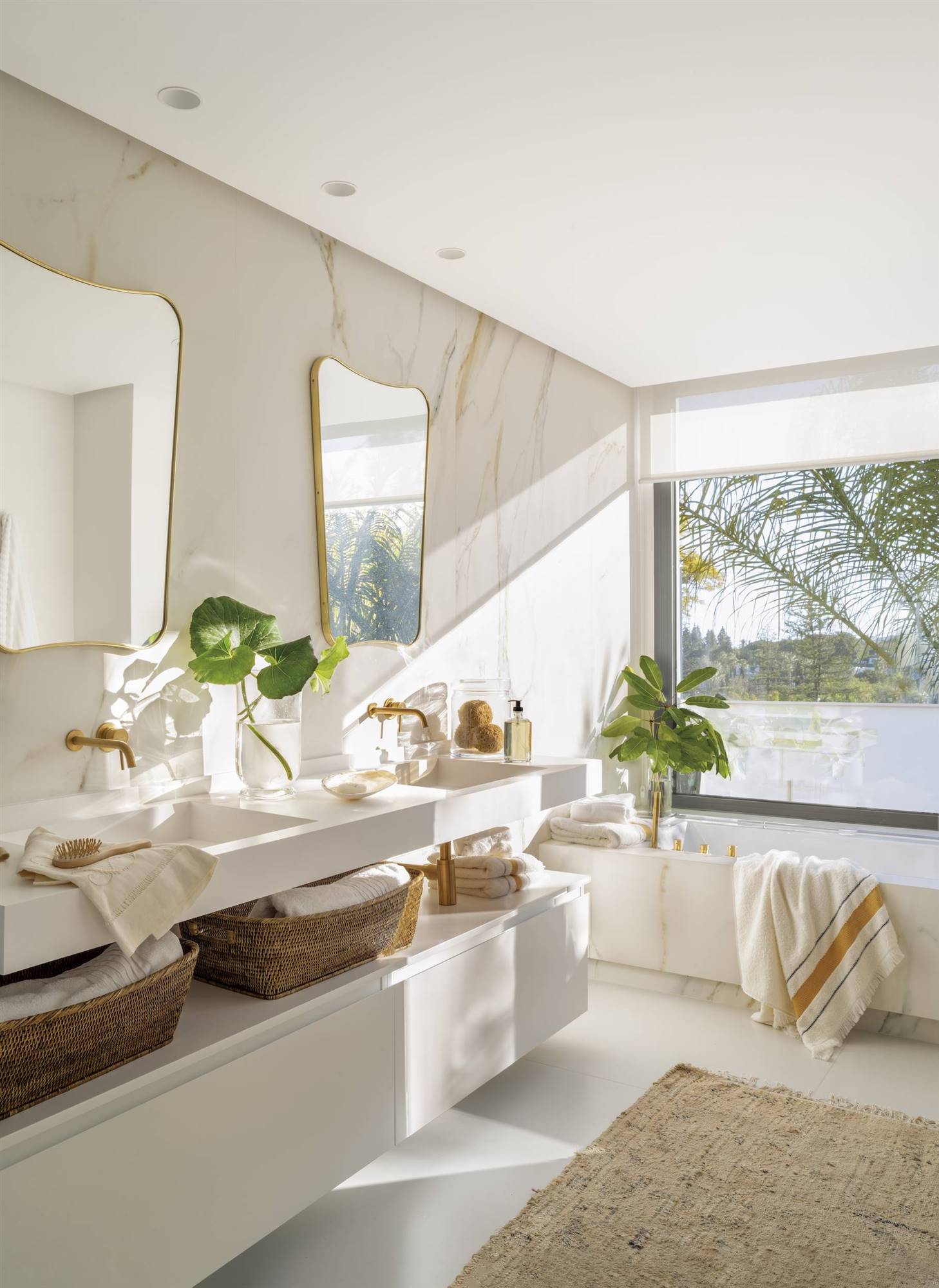 Baño moderno con mueble blanco y paredes de mármol. 