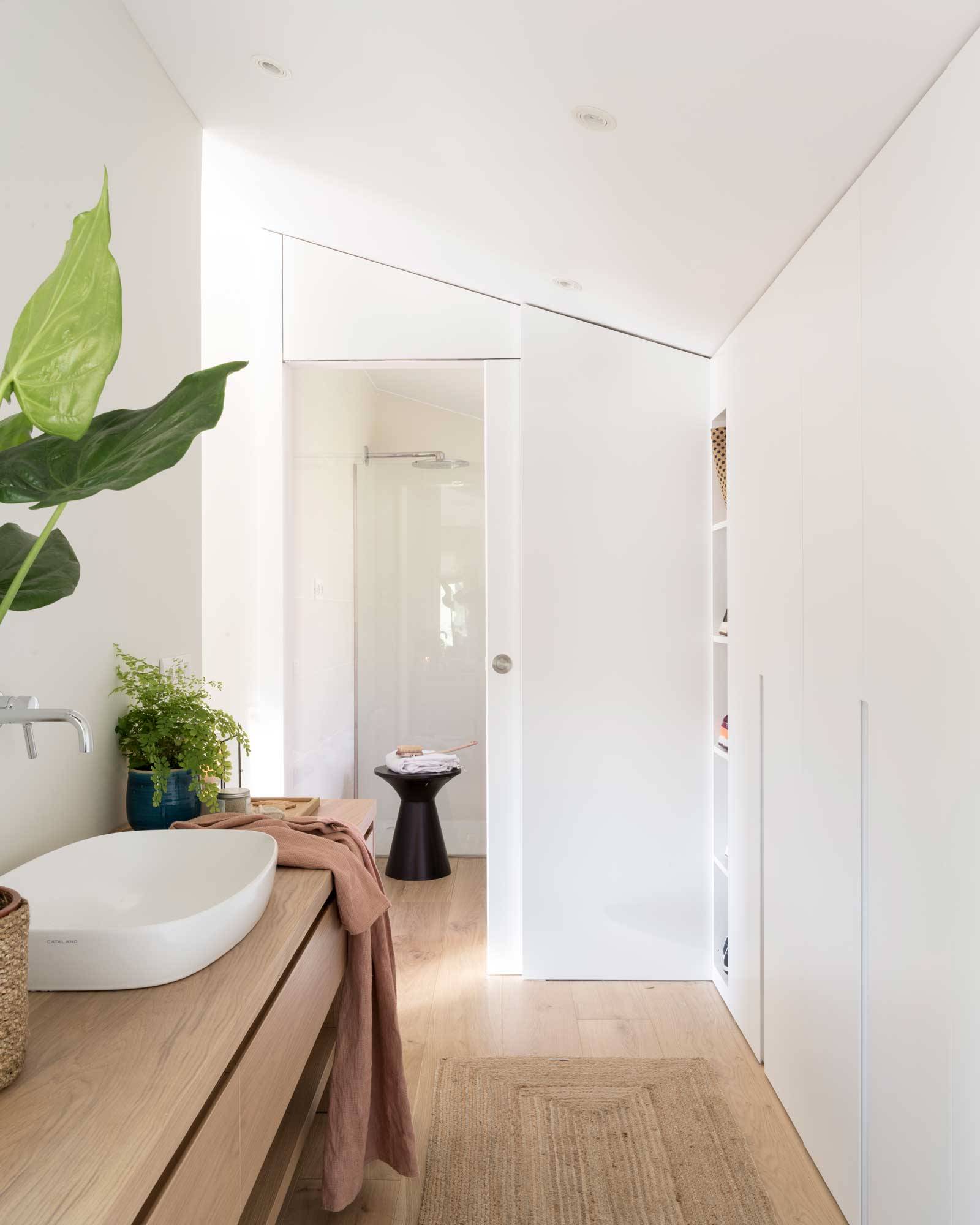 Baño moderno en blanco con vestidor. 