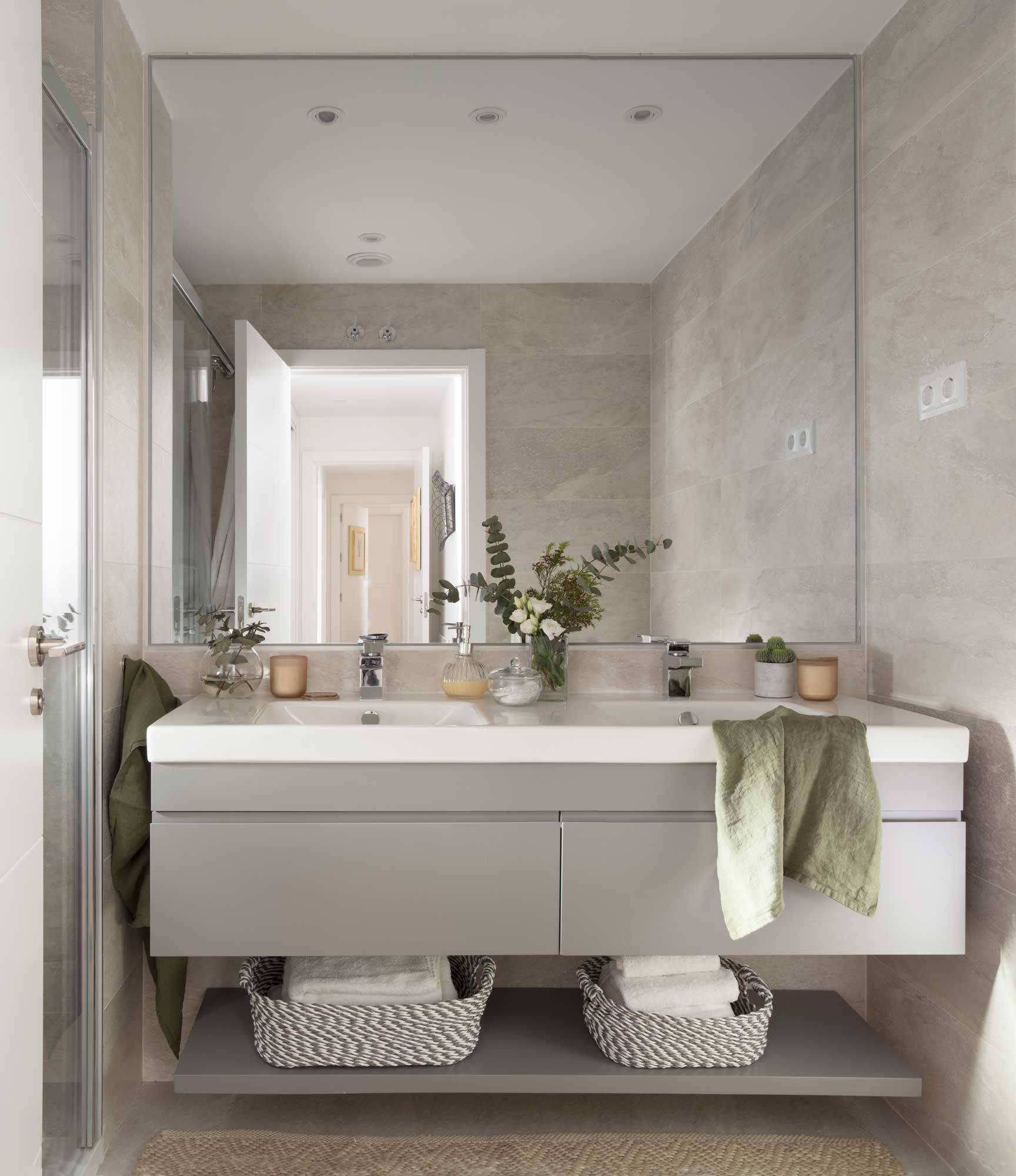 Baño moderno con mueble gris suspendido.