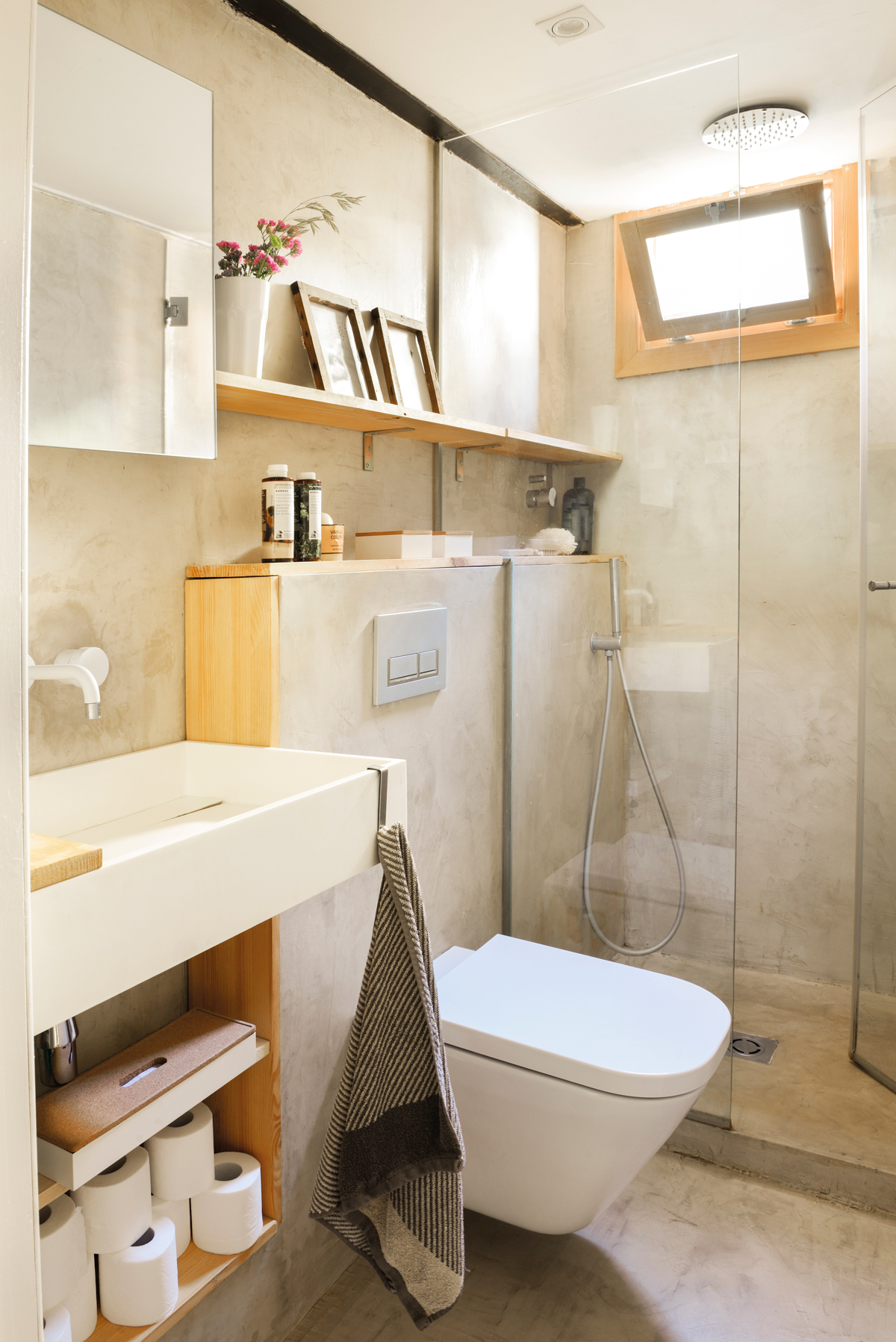 Baño moderno con cisterna empotrada y revestido con microcemento.
