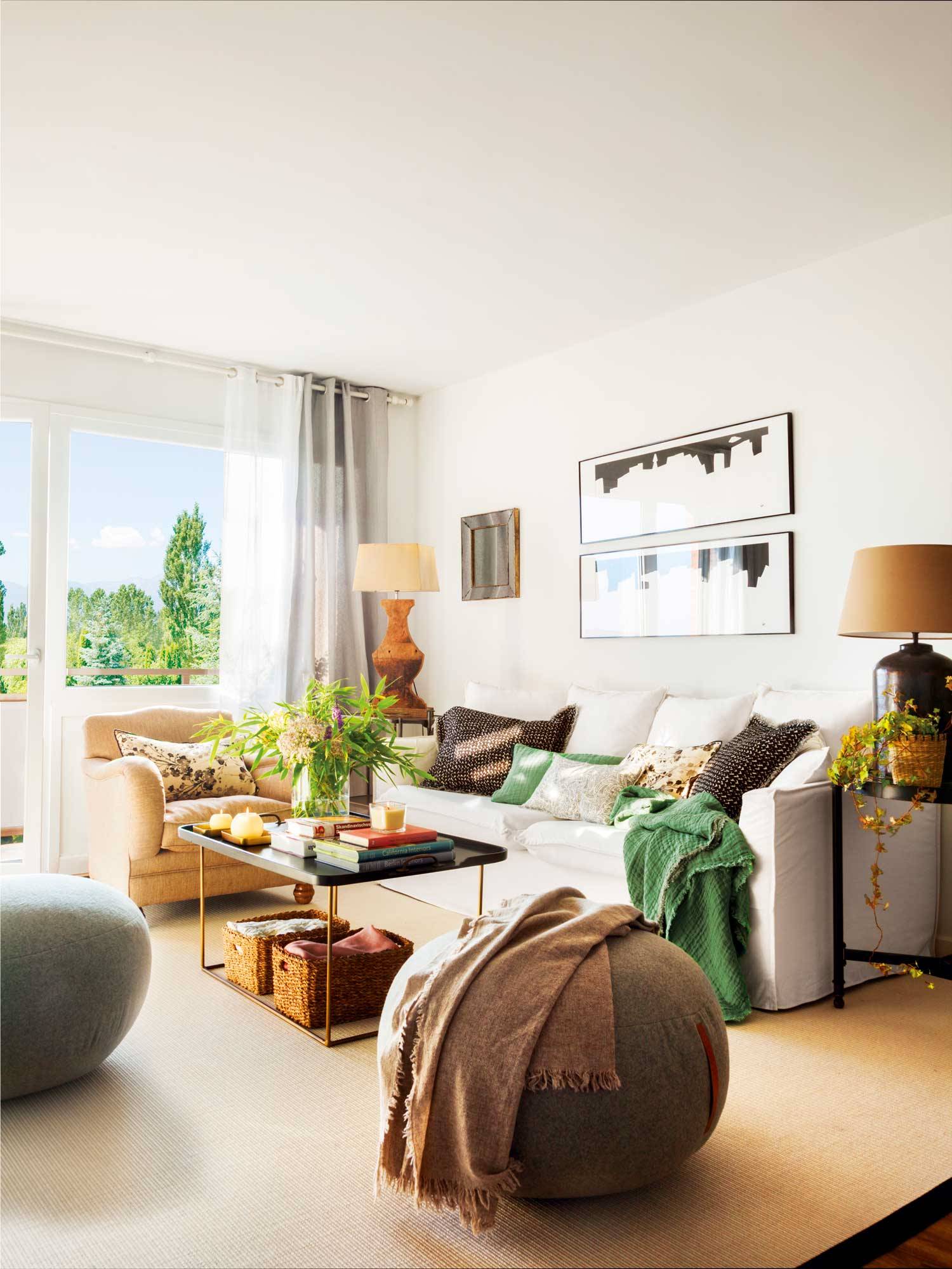 Salón con sofá blanco y detalles en verde y negro. 