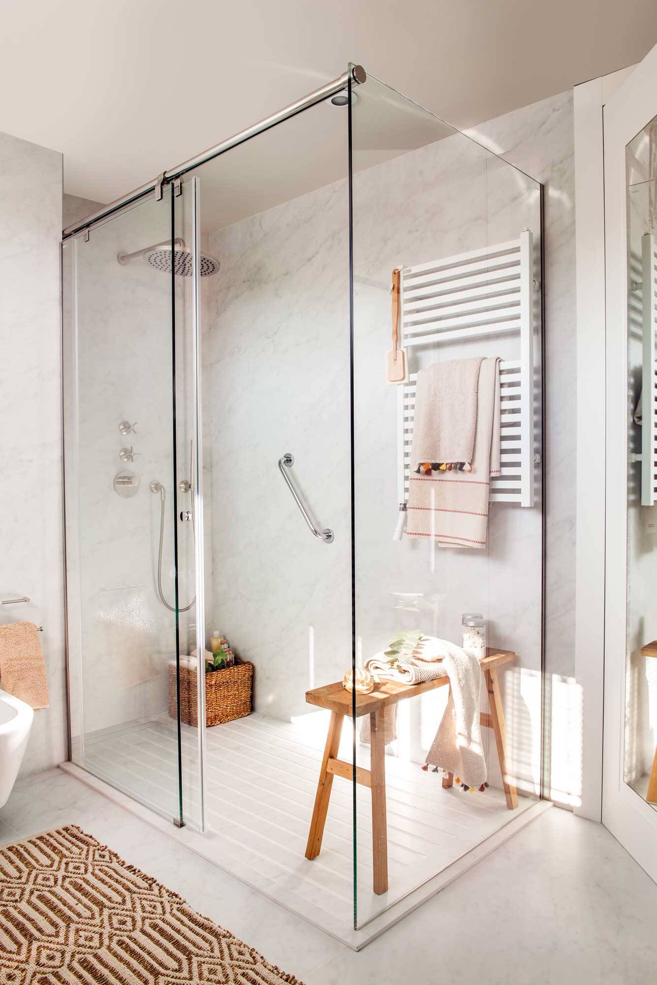 Baño moderno con ducha revestida con Neolith con acabado mármol y mampara. 