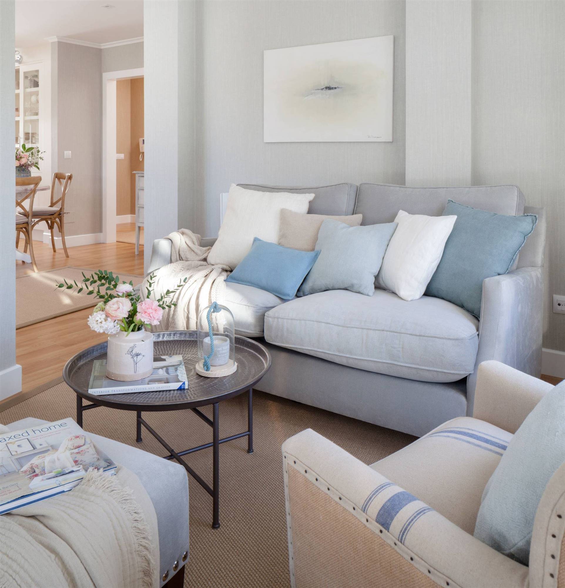 Salón pequeño con sofá azul y mesa de centro metálica de estilo árabe. 