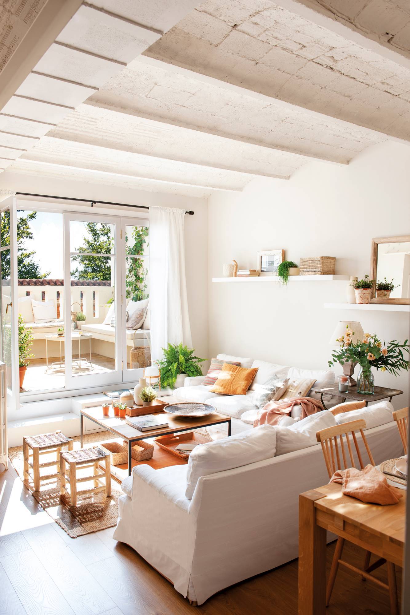 Salón pequeño con sofás blancos y mesa de centro de madera. 