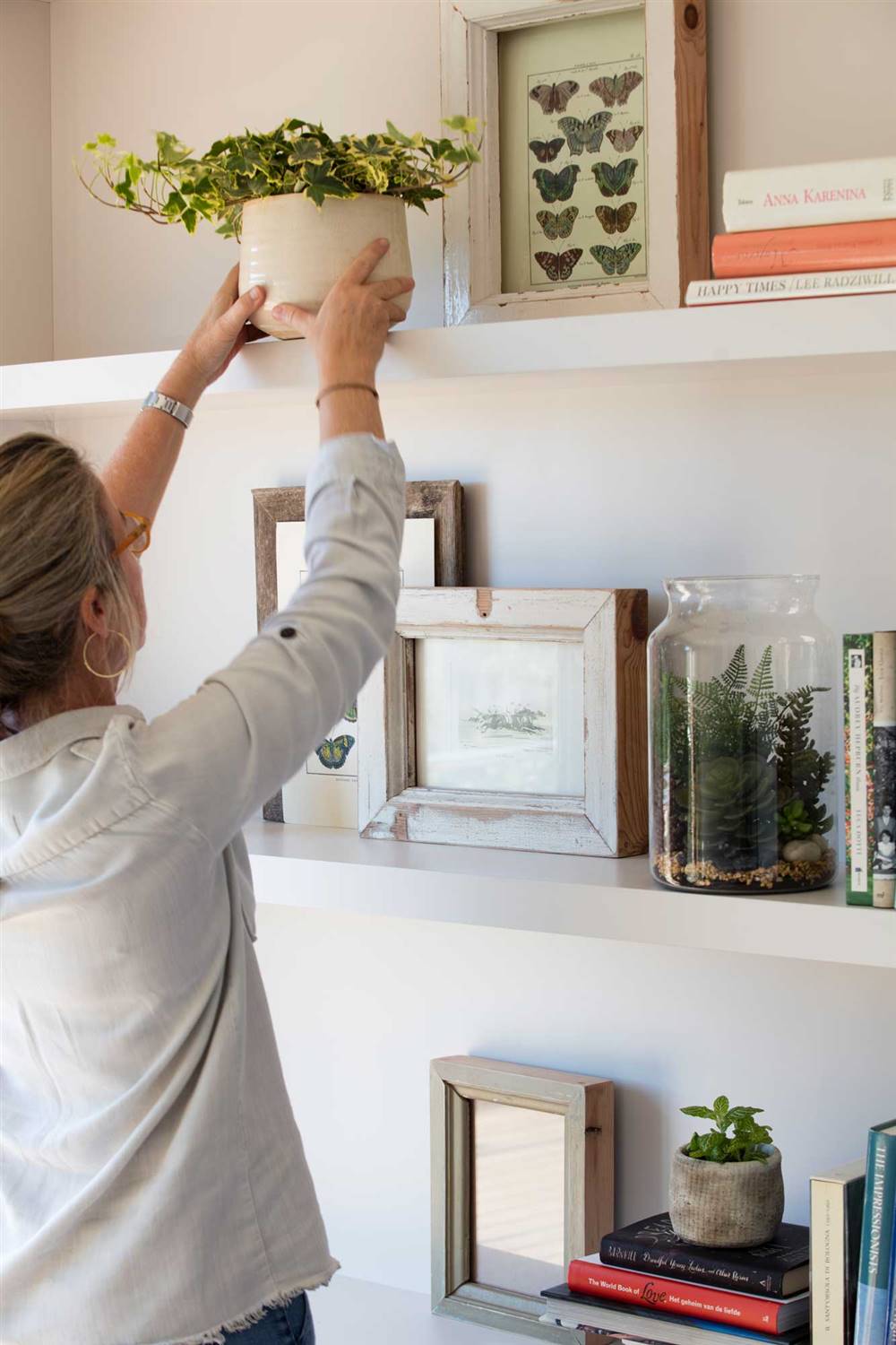 mujer-ordenando-y-decorando-estanteria