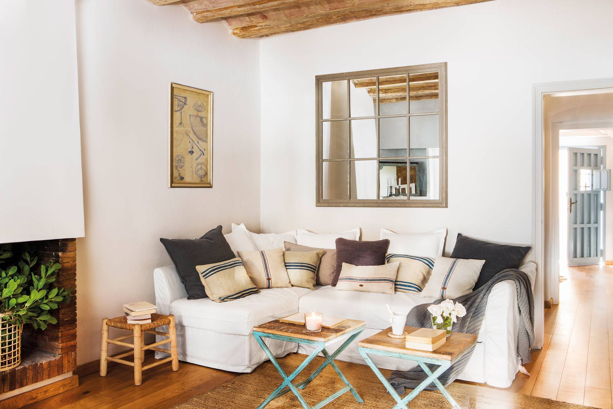 Salón con sofá blanco y mesas de centro de madera. 