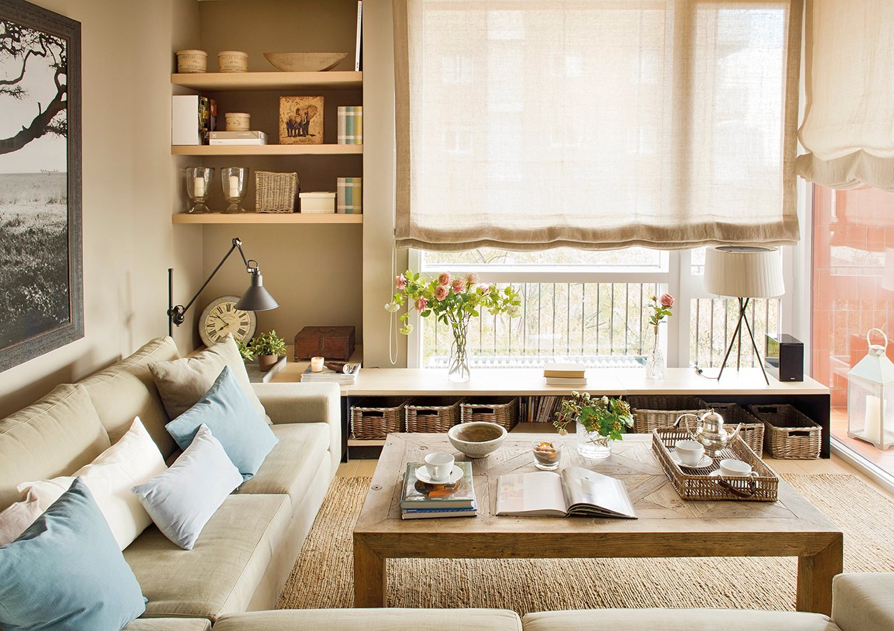 Salón con sofá rinconero y banco a medida debajo de la ventana. 