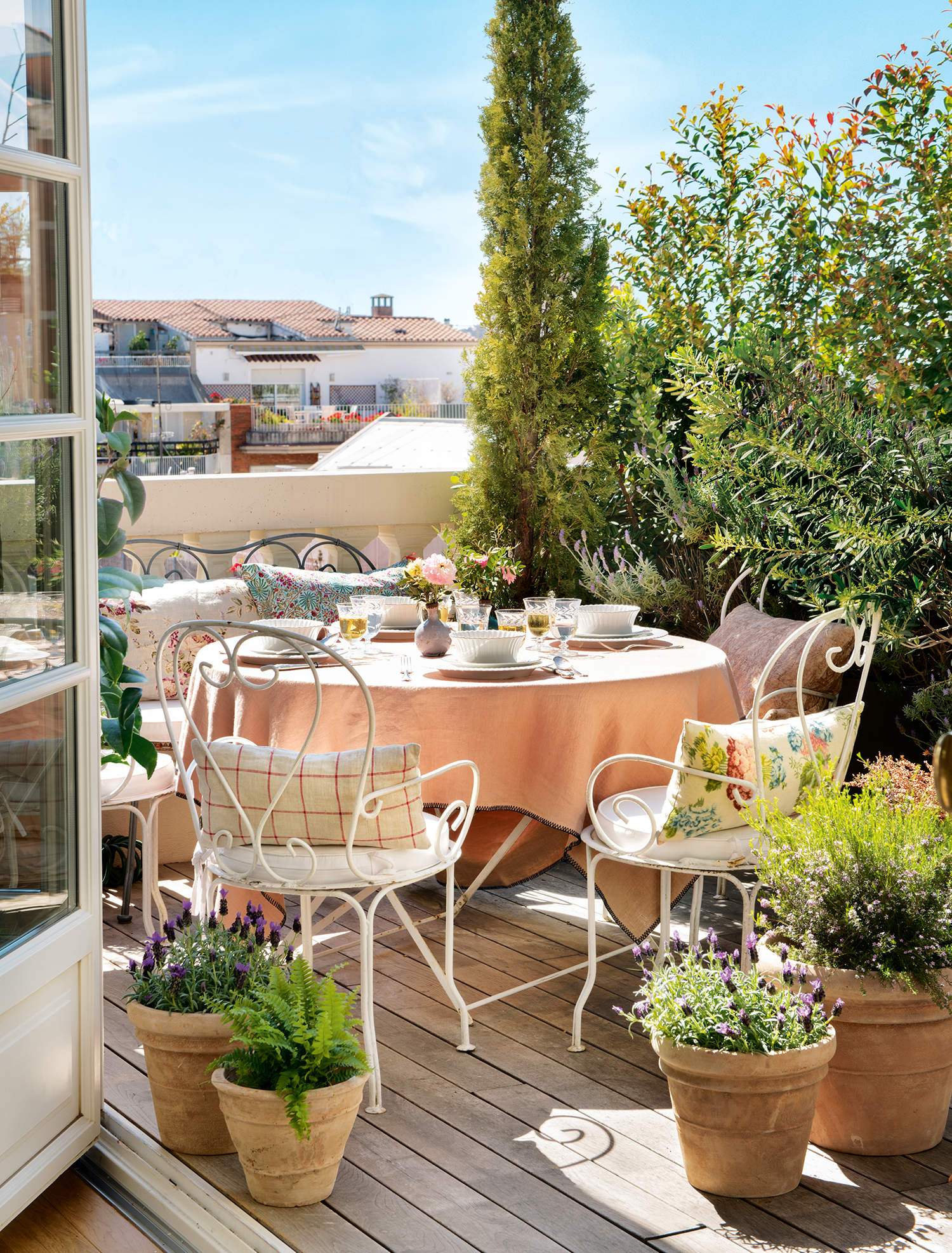 Terraza con romántico comedor con muebles de hierro y plantas