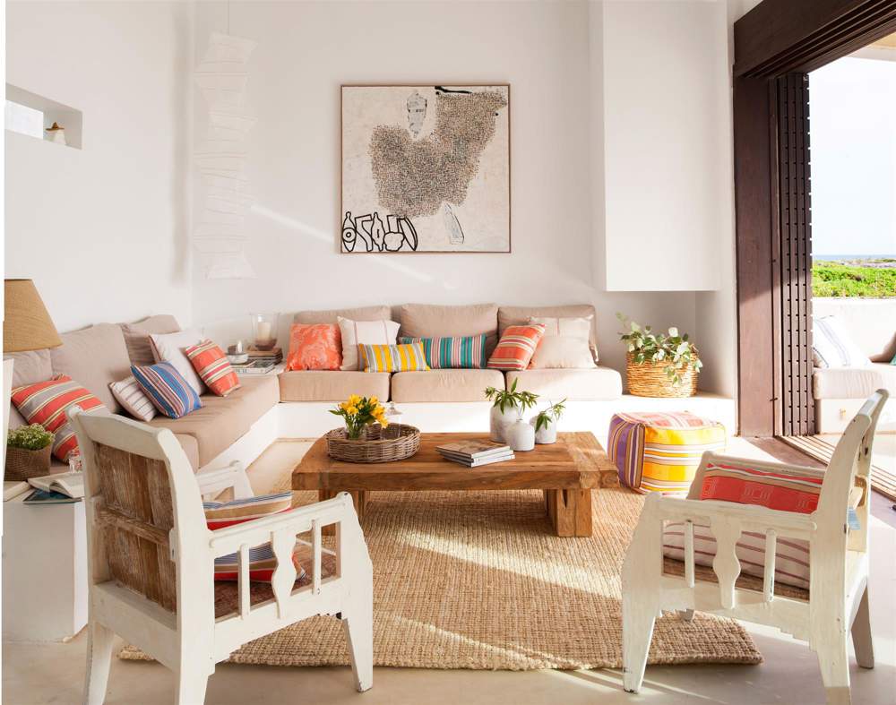 Un salón con acceso al exterior y sofás de obra