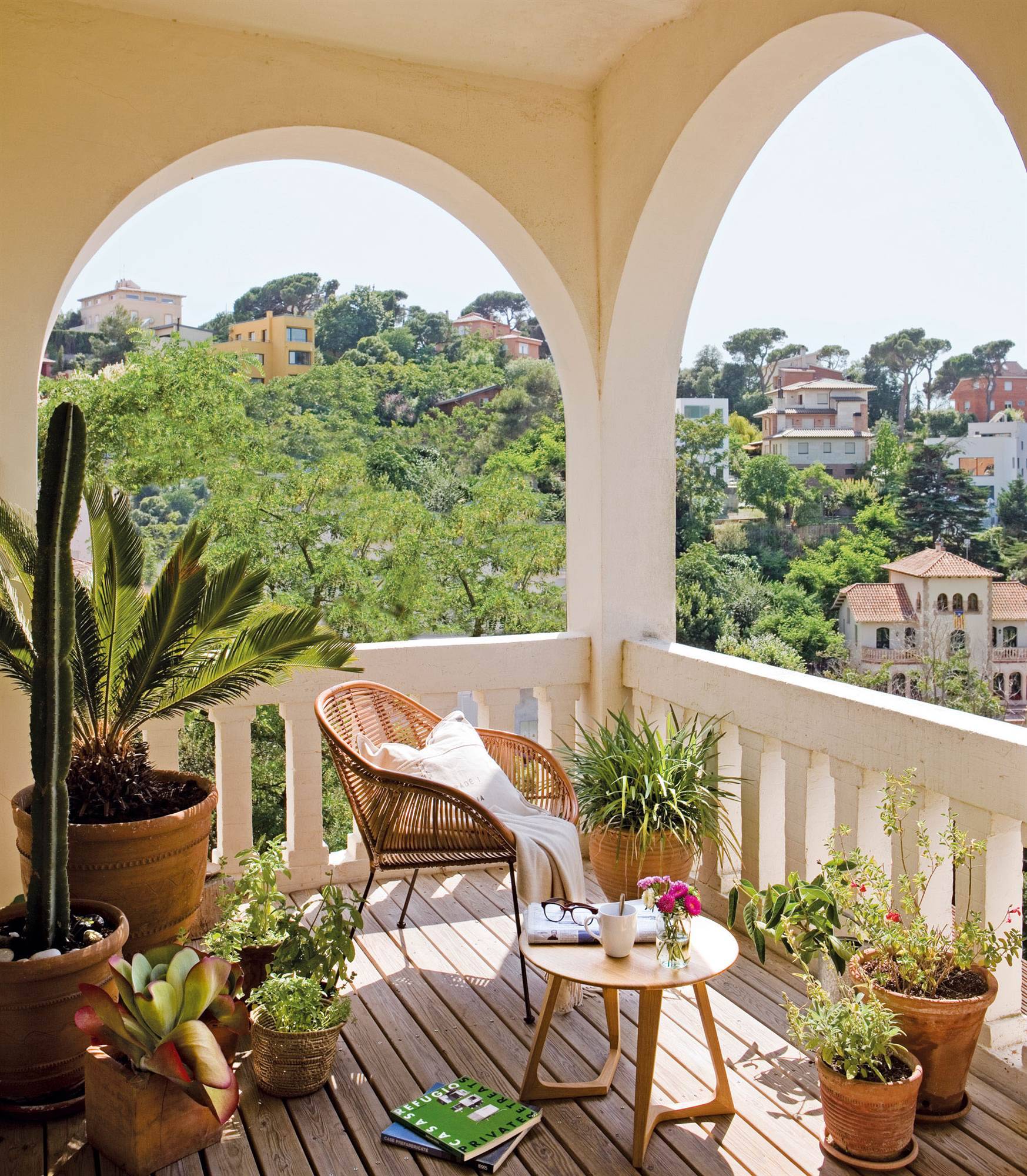 Terraza pequeña con una butaca y plantas. 